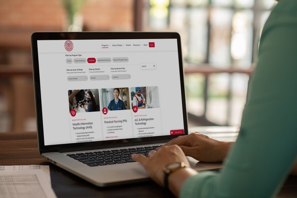 Mockup image of woman using a laptop computer with ACCS website on the screen.